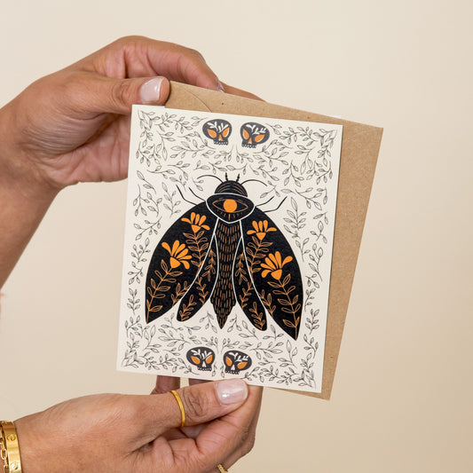 Dark Omens Moth greeting card held in hand