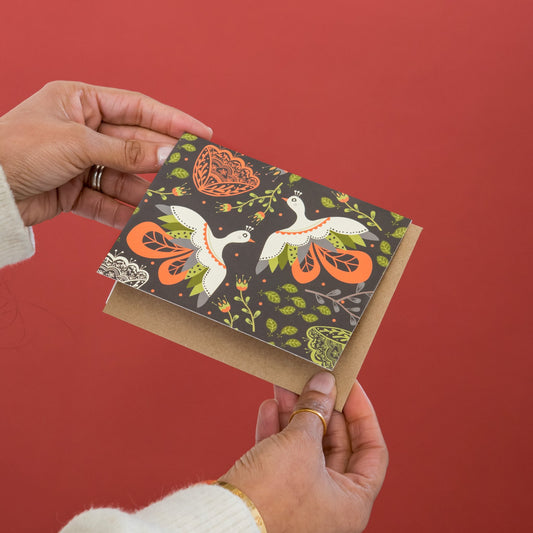 Blooming Folk Birds greeting card held in hand