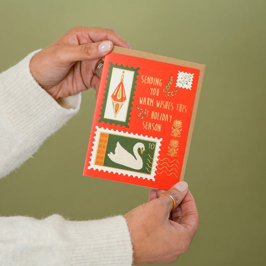 Holiday Stamps greeting card held in hand