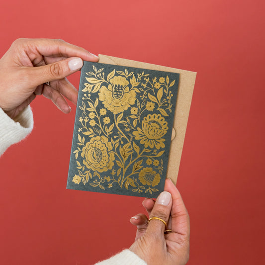 Golden Blooms greeting card held in hand