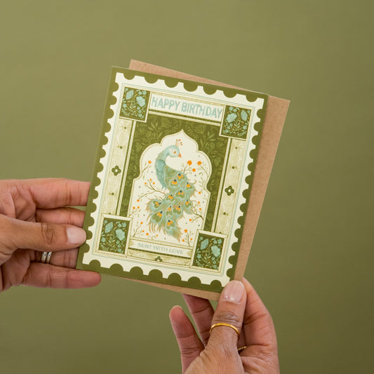 Peacock Stamp Birthday greeting card held in hand