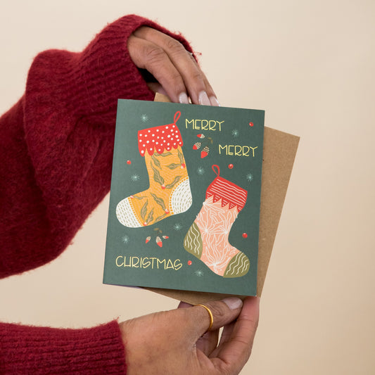 Christmas Morning Stockings greeting card held in hand