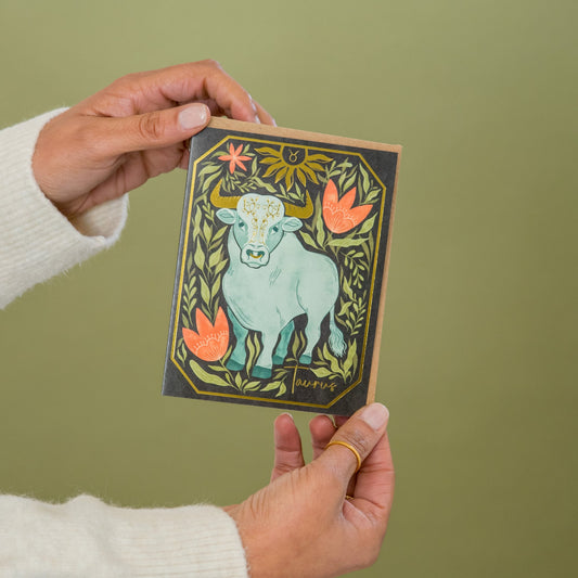 Taurus Zodiac Garden greeting card held in hand