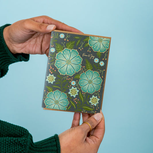 Peace and Joy greeting card held in hand