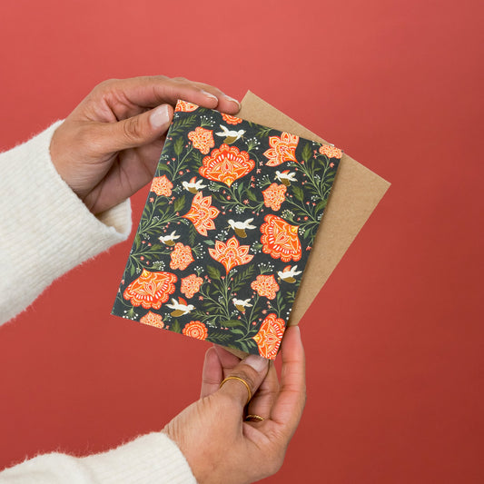 Red Floral Doves greeting card held in hand