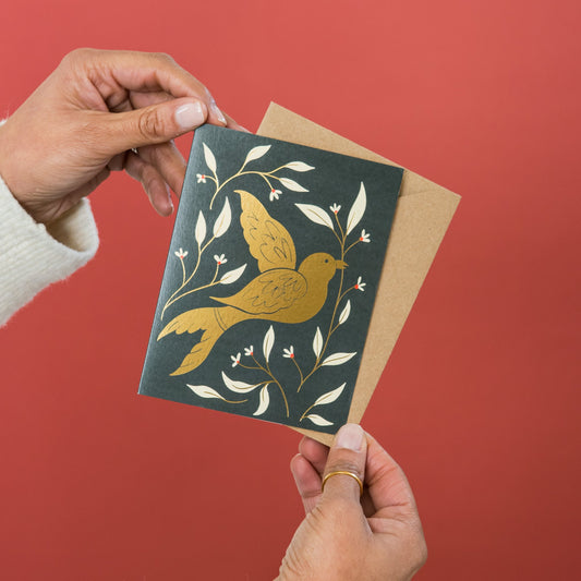 Golden Bird greeting card held in hand