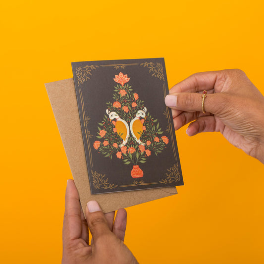 Peacock Christmas Tree greeting card held in hand