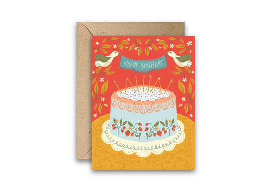 Strawberry Cake Birthday Greeting Card featuring a hand-illustrated blue cake decorated with strawberries, lit candles, and two birds holding a “Happy Birthday” banner on a bright red and golden yellow floral background, shown with a kraft envelope.