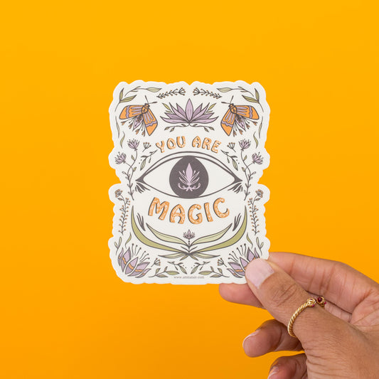 You Are Magic vinyl sticker held in hand, butterflies and scrollwork around a single eye by Amita Nair