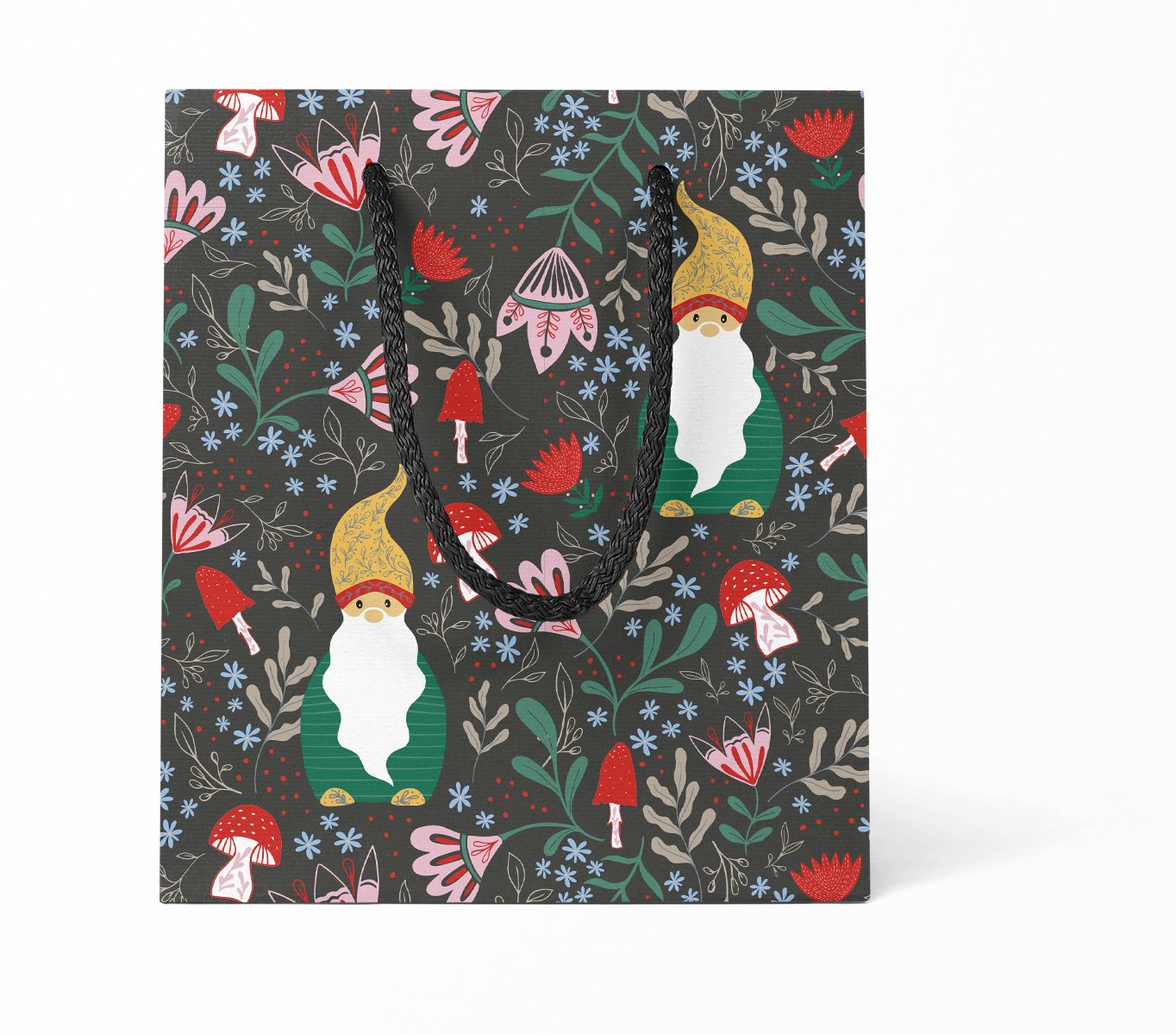 Berry Gnome Gift Bag - Berry Gnome gift bag featuring hand-illustrated gnomes surrounded by flowers, mushrooms, and greenery on a dark charcoal background, finished with black rope handles and made from sturdy coated paper.